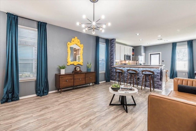 living area featuring light wood finished floors, a chandelier, recessed lighting, and baseboards