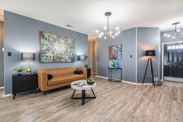 living room featuring visible vents, baseboards, an inviting chandelier, and wood finished floors