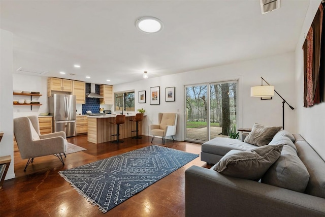 living room featuring recessed lighting, visible vents, plenty of natural light, and finished concrete flooring