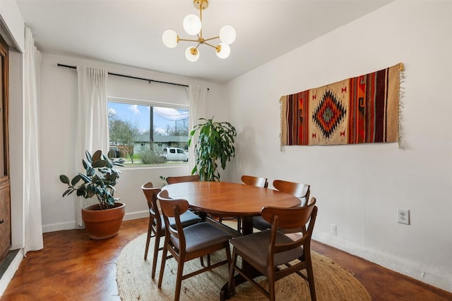 dining space with baseboards, concrete floors, and a chandelier