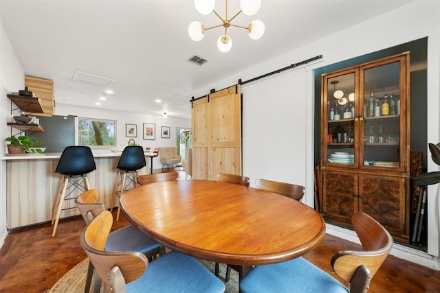 dining room featuring a notable chandelier, visible vents, concrete floors, and a barn door