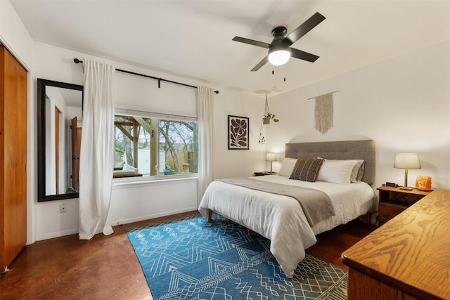 bedroom with baseboards, concrete flooring, and a ceiling fan