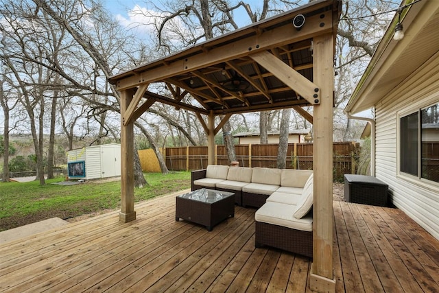 wooden terrace with an outbuilding, a fenced backyard, a shed, a yard, and an outdoor hangout area