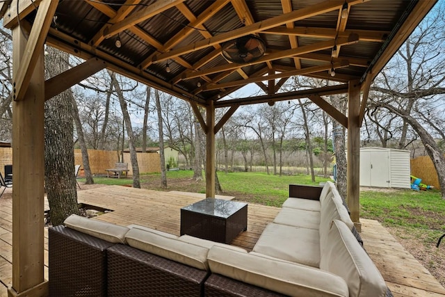 view of patio featuring an outbuilding, fence, a shed, a deck, and an outdoor hangout area