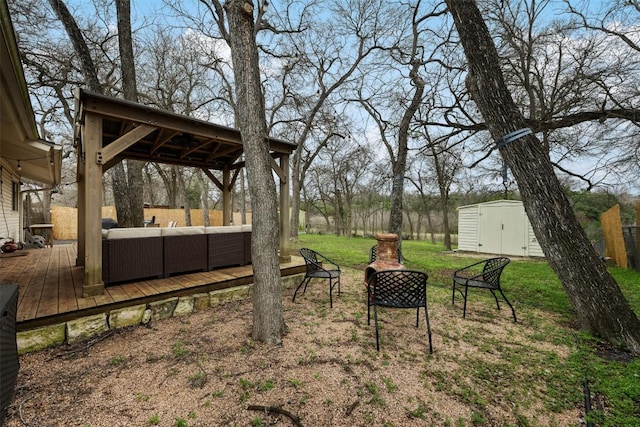 view of yard with fence, an outdoor hangout area, a storage shed, an outdoor structure, and a deck