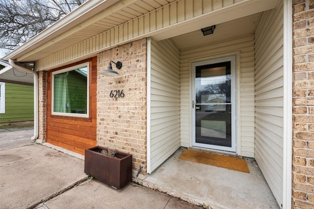 view of exterior entry with brick siding