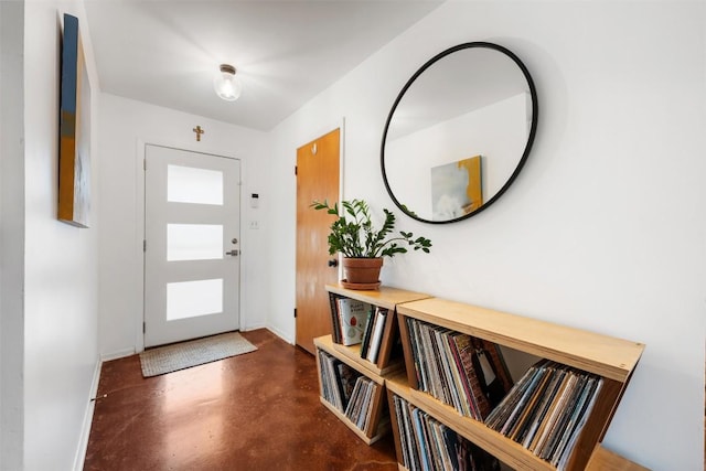 foyer with finished concrete flooring and baseboards