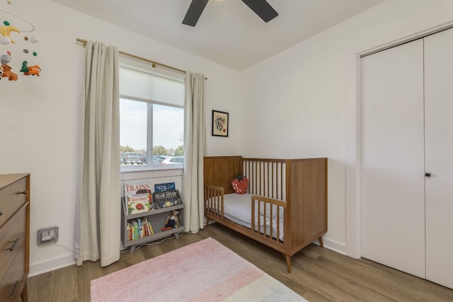 bedroom with ceiling fan, a closet, baseboards, and wood finished floors