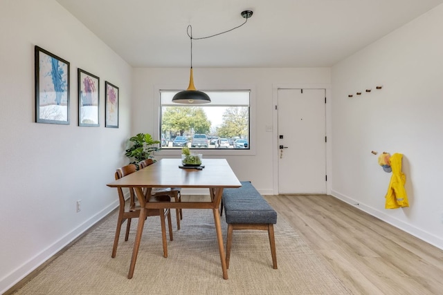 dining room featuring light wood-style flooring and baseboards