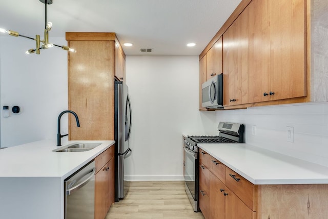 kitchen with a sink, stainless steel appliances, visible vents, and light countertops