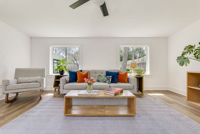 living room with a wealth of natural light, baseboards, and wood finished floors