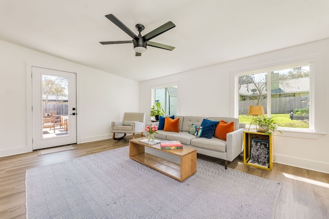 living room with a wealth of natural light, baseboards, wood finished floors, and a ceiling fan