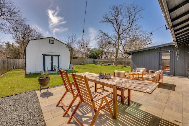 view of patio with an outdoor structure, outdoor dining area, and a fenced backyard