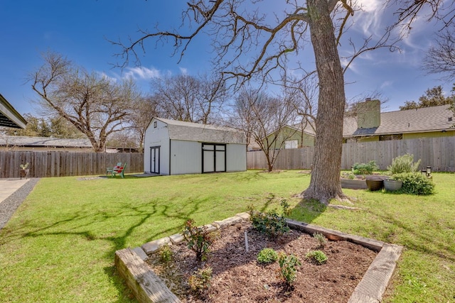 view of yard featuring a storage unit, a fenced backyard, a vegetable garden, and an outdoor structure