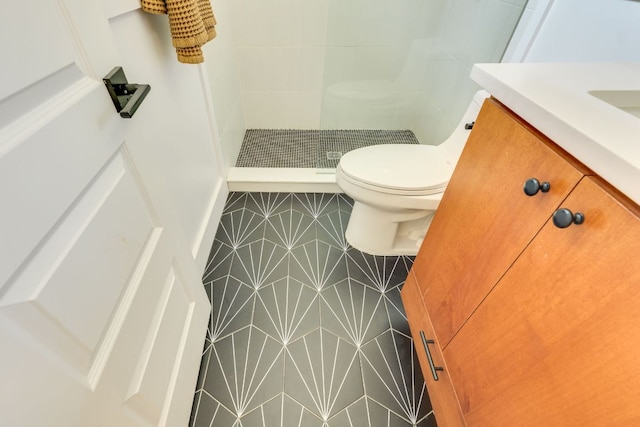 full bath featuring tile patterned flooring, a stall shower, toilet, and vanity