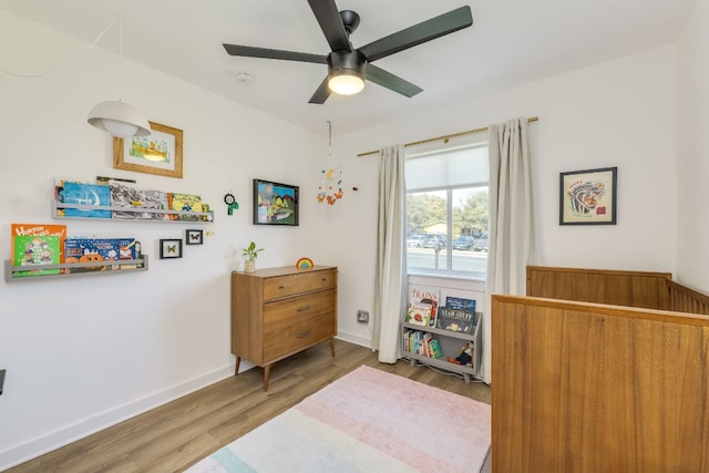 interior space with ceiling fan, baseboards, and wood finished floors