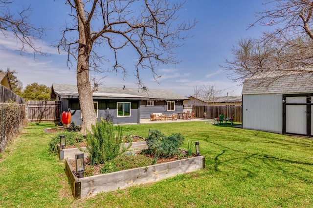 rear view of house featuring a storage unit, an outbuilding, a vegetable garden, and a fenced backyard