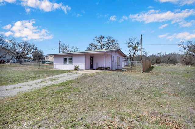 exterior space featuring a front lawn, fence, driveway, and a carport