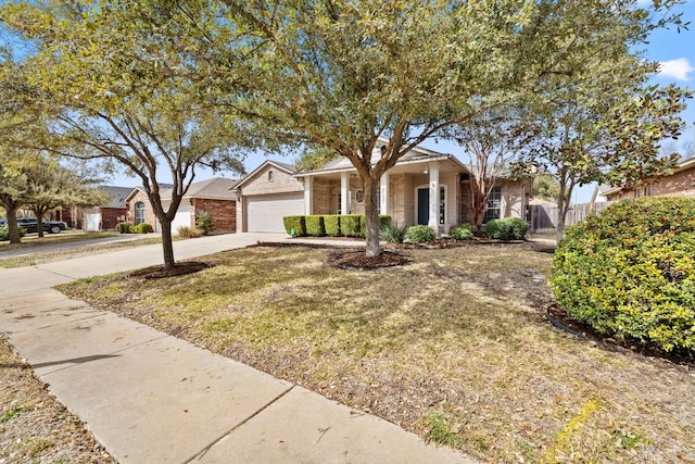 ranch-style home featuring brick siding, driveway, an attached garage, and fence