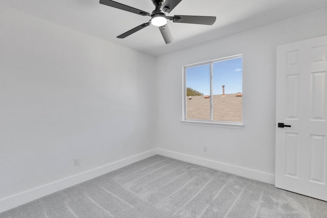 spare room with baseboards, light colored carpet, and a ceiling fan