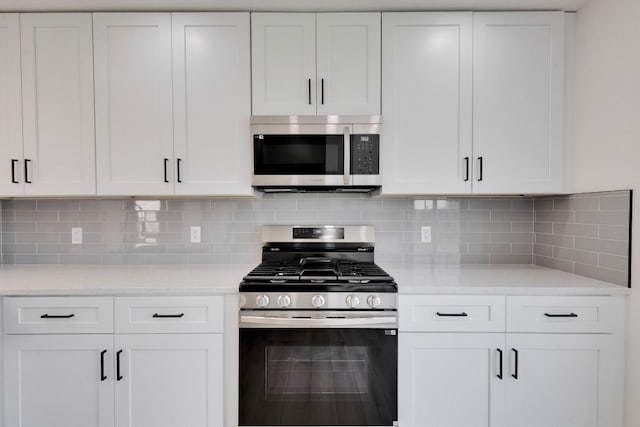 kitchen with white cabinetry, backsplash, and appliances with stainless steel finishes