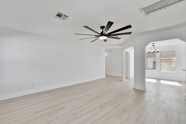 unfurnished living room with arched walkways, visible vents, ceiling fan with notable chandelier, and light wood-style flooring