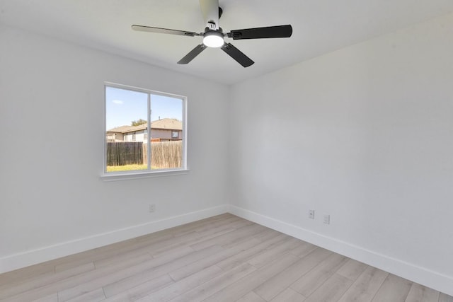 spare room featuring light wood-style flooring, baseboards, and ceiling fan