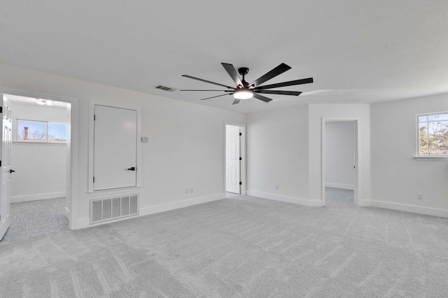 empty room with visible vents, light colored carpet, and baseboards