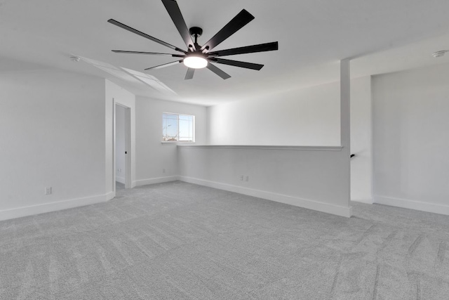 carpeted empty room featuring a ceiling fan and baseboards