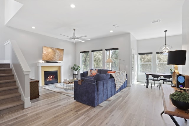 living room with stairs, recessed lighting, visible vents, and light wood finished floors