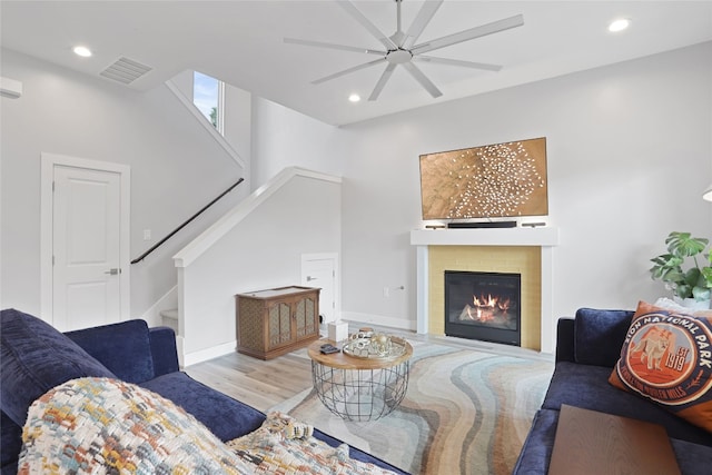 living area featuring recessed lighting, visible vents, wood finished floors, and stairway