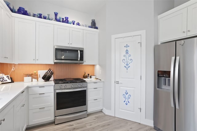 kitchen featuring white cabinetry, light countertops, tasteful backsplash, and stainless steel appliances