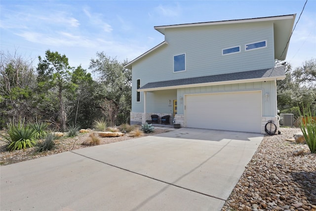 exterior space with central air condition unit, board and batten siding, concrete driveway, and stone siding