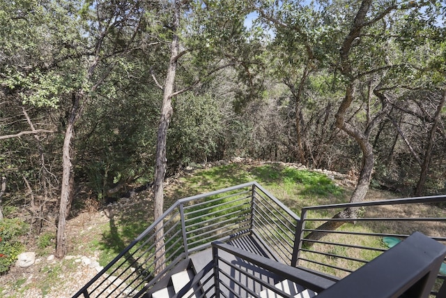 wooden terrace featuring a wooded view