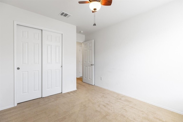 unfurnished bedroom with visible vents, carpet floors, a closet, and a ceiling fan