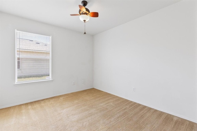 empty room featuring a ceiling fan and carpet