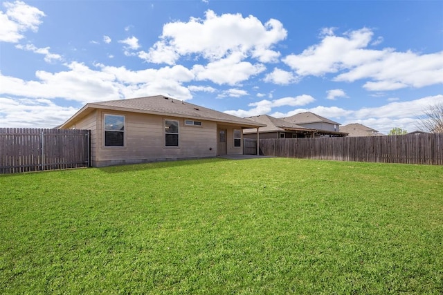 rear view of property with a lawn and a fenced backyard