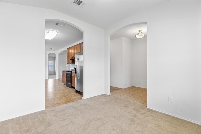 unfurnished room with light tile patterned floors, light colored carpet, and visible vents