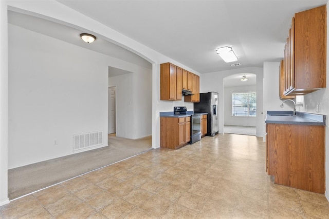 kitchen featuring visible vents, a sink, under cabinet range hood, stainless steel appliances, and arched walkways