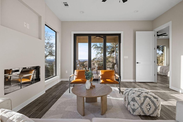 sitting room featuring visible vents, a ceiling fan, baseboards, and wood finished floors