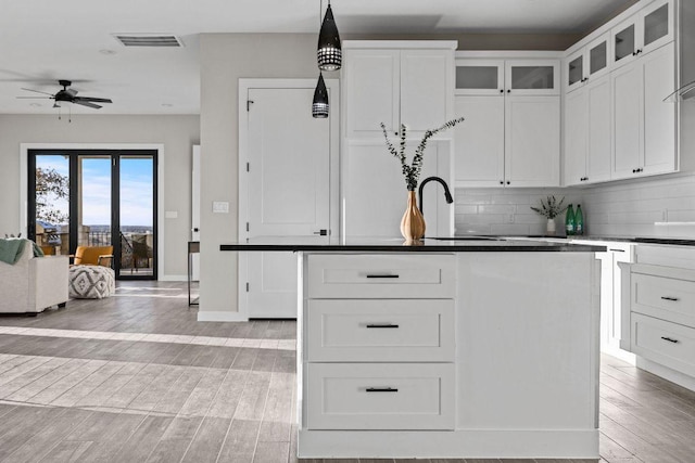 kitchen with visible vents, white cabinetry, tasteful backsplash, and light wood finished floors