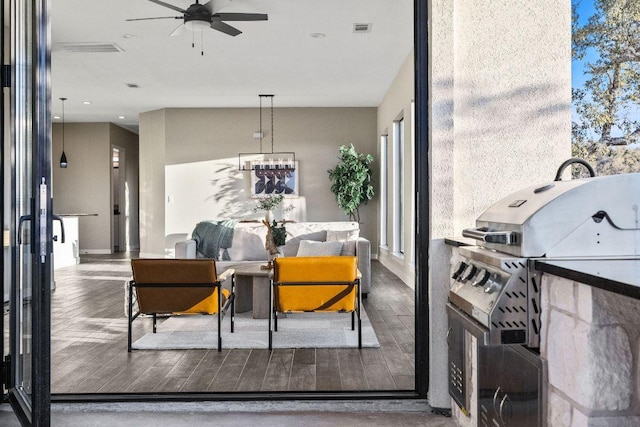 living area featuring visible vents, wood finished floors, and a ceiling fan