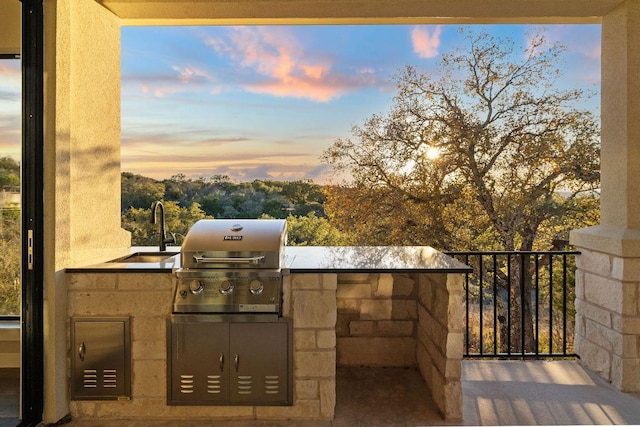 view of patio featuring exterior kitchen, area for grilling, and a sink