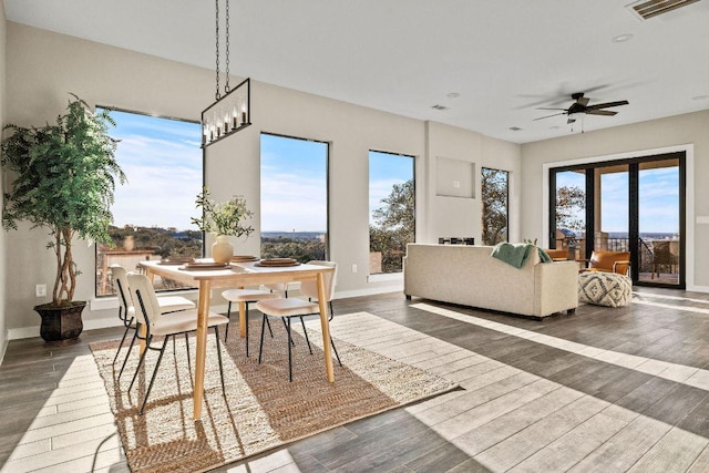 dining space with a ceiling fan, wood finished floors, visible vents, and baseboards