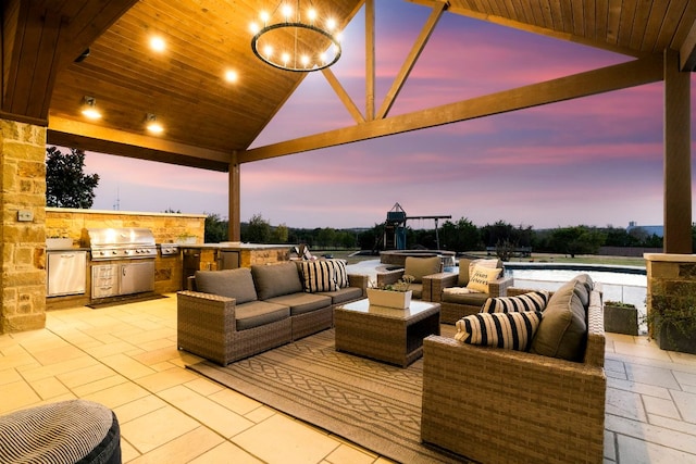 patio terrace at dusk with an outdoor living space and area for grilling