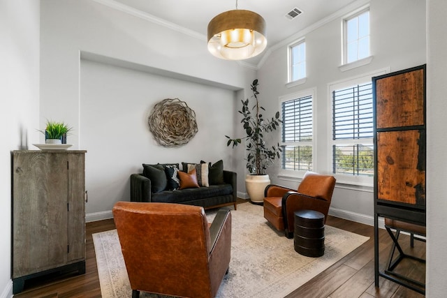 living room with crown molding, baseboards, and wood finished floors