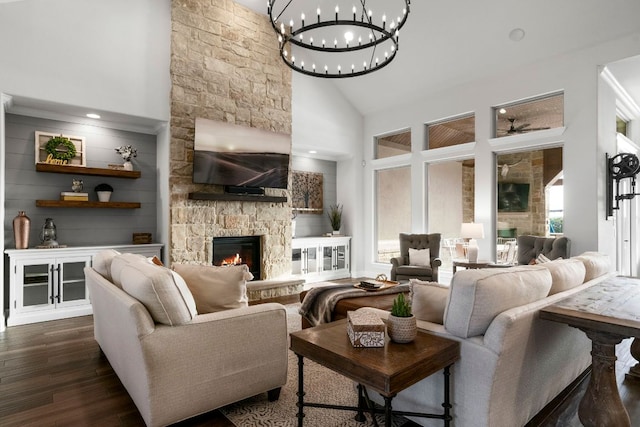 living room with a ceiling fan, a high ceiling, a stone fireplace, and dark wood-style flooring