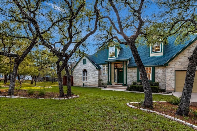 view of front facade featuring a garage, roof with shingles, a front lawn, and fence