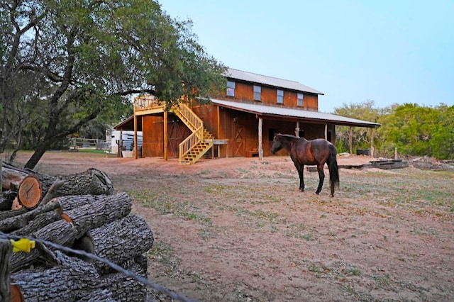 back of property featuring an exterior structure, metal roof, and an outdoor structure