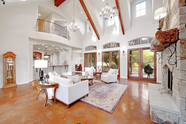 living room featuring plenty of natural light, a stone fireplace, french doors, concrete flooring, and a chandelier